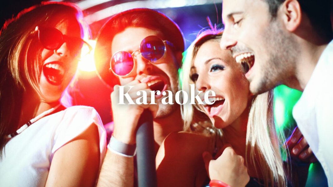 Friends singing karaoke in a private room with microphones and a song screen